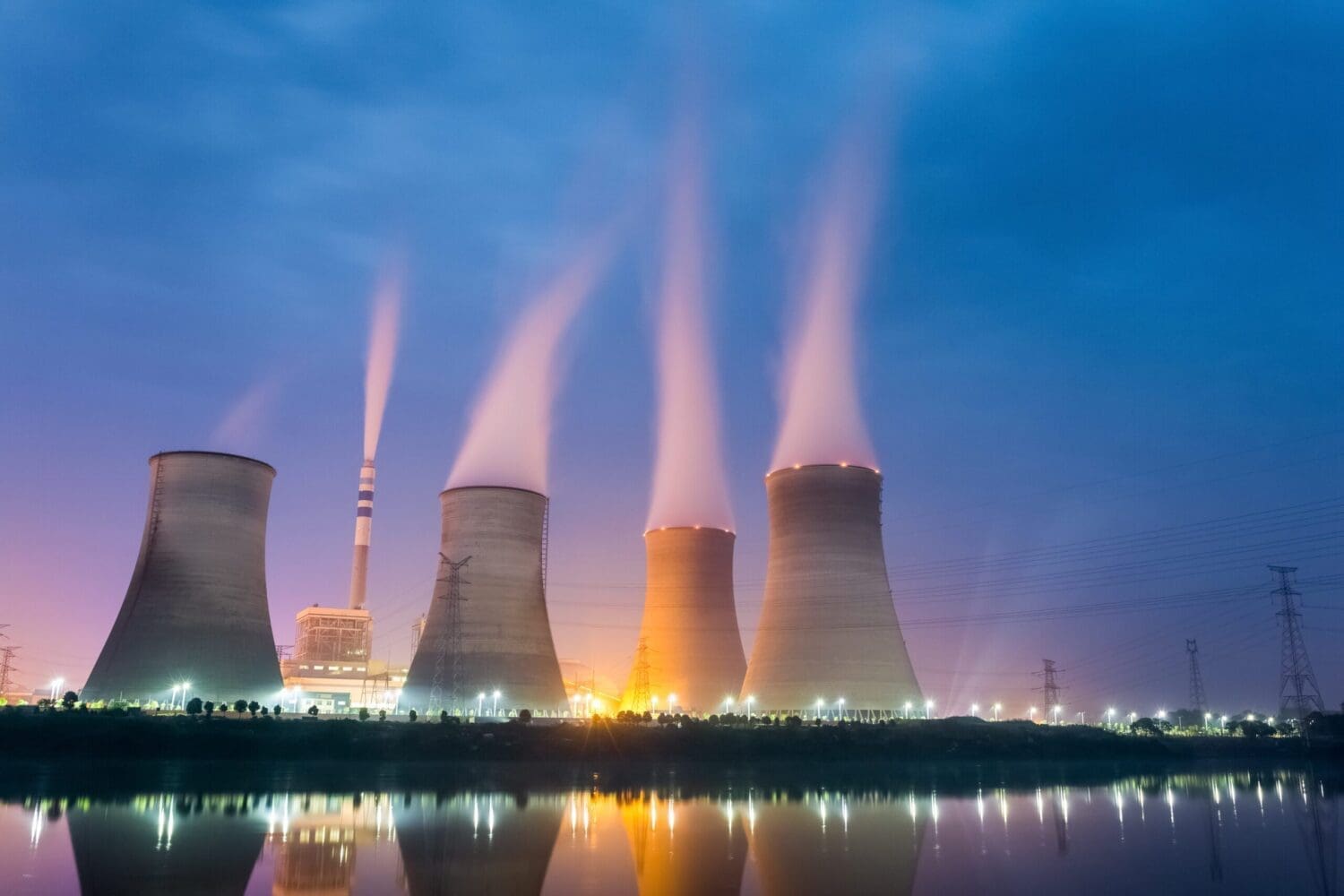 Power plant at night, cooling tower closeup with steam