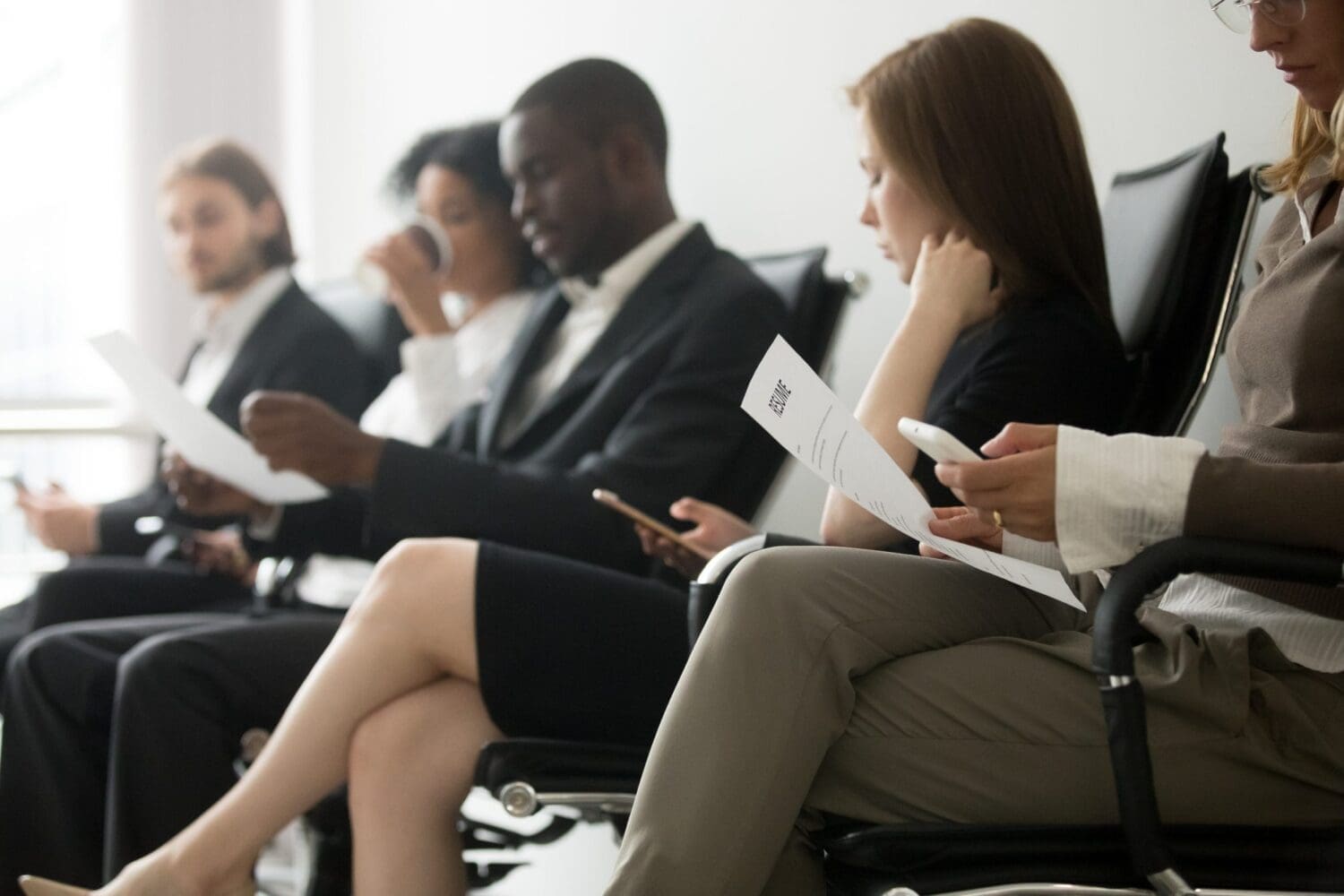 Multi-ethnic applicants sitting in queue preparing for interview